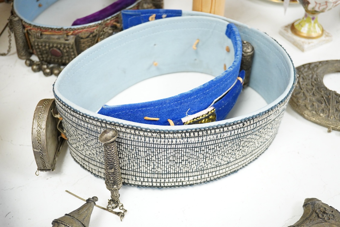 Two Yemeni white metal daggers white and two belts, largest dagger 31cm long